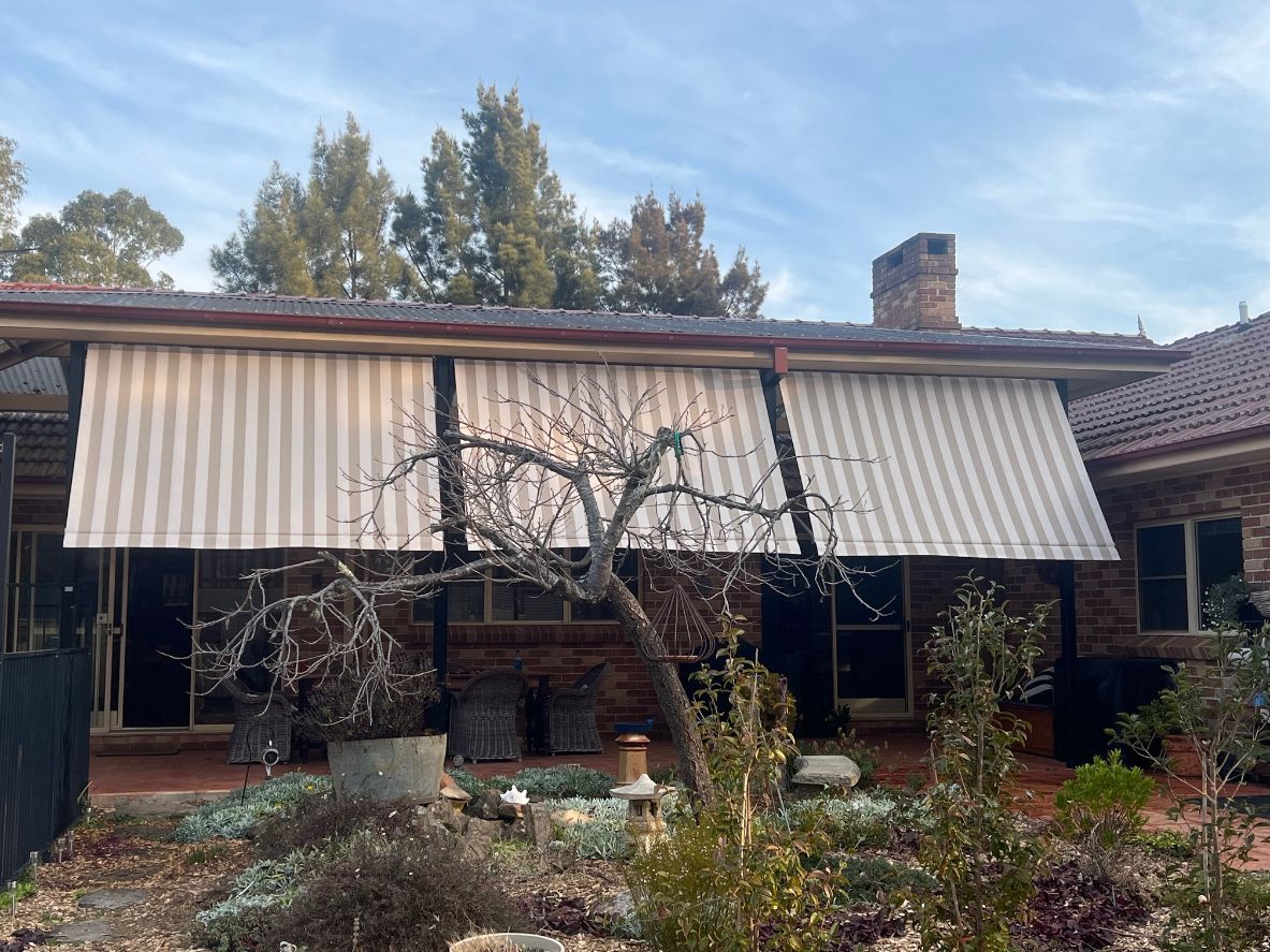 A house with a striped awning on the porch.