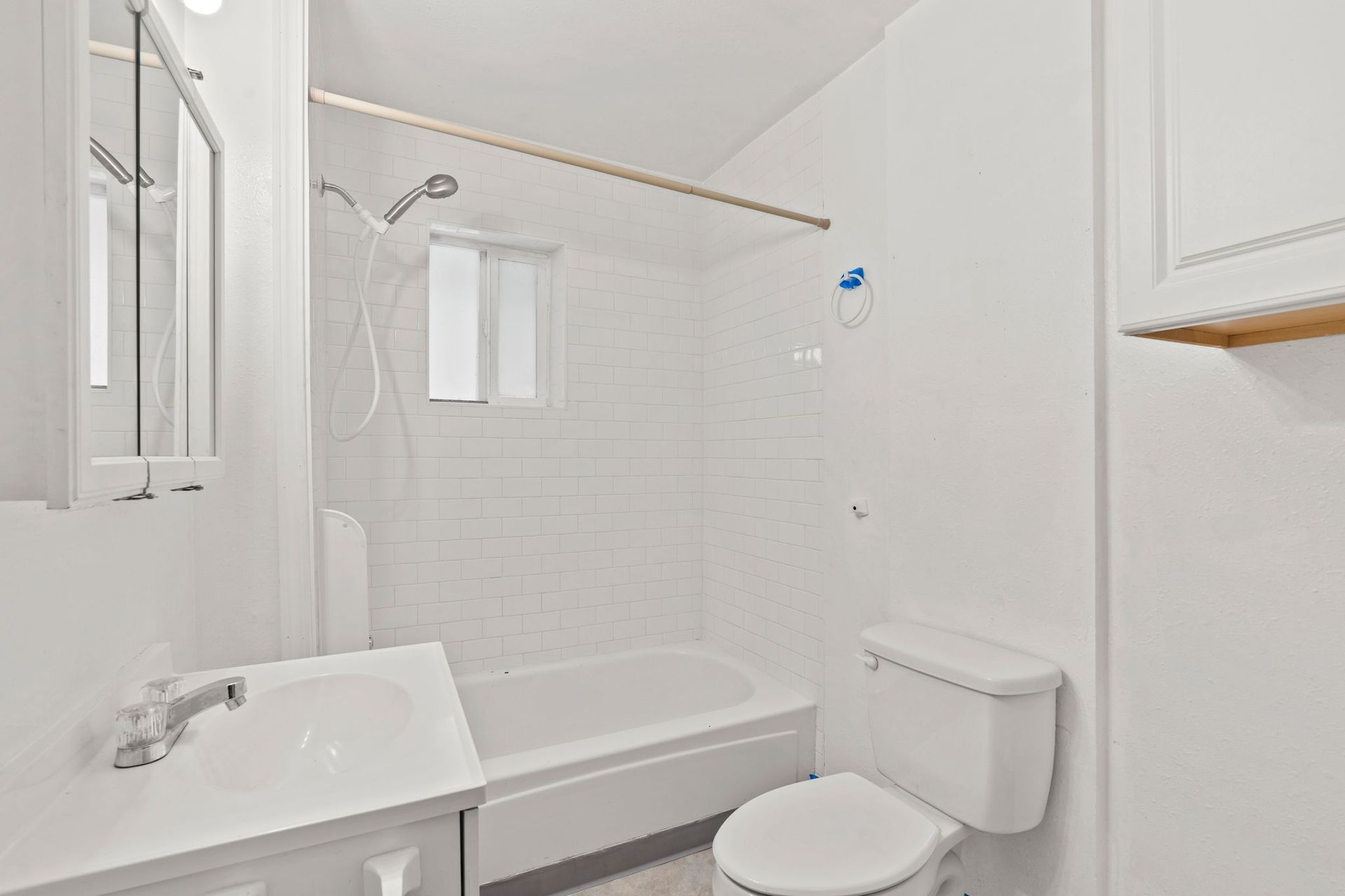 White bathroom with a sink, toilet, and shower/tub combo.