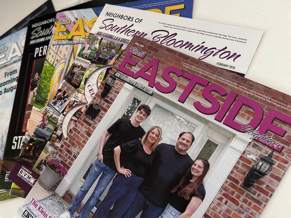 Stack of Eastside magazines with a smiling group on the cover