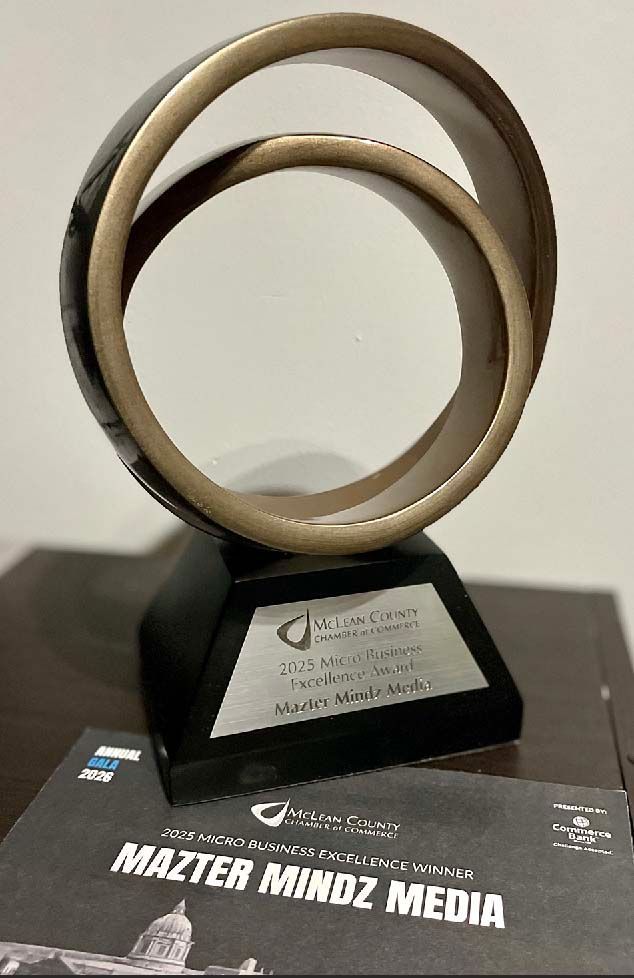 Gold award trophy on black base labeled “WALTER MINDZ MEDIA” displayed on a table.