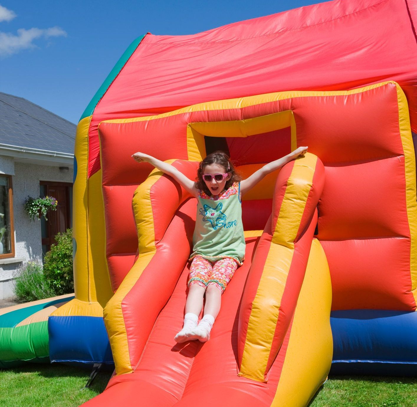 Girl Outstretched Her Arm on Sliding on the Bouncy House | Rancho Cucamonga, CA | Jam Jam Bounce house and inflatable party 