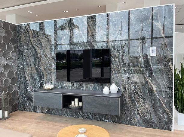 Living room wall with a mounted TV, floating cabinet, and marble-like paneling.
