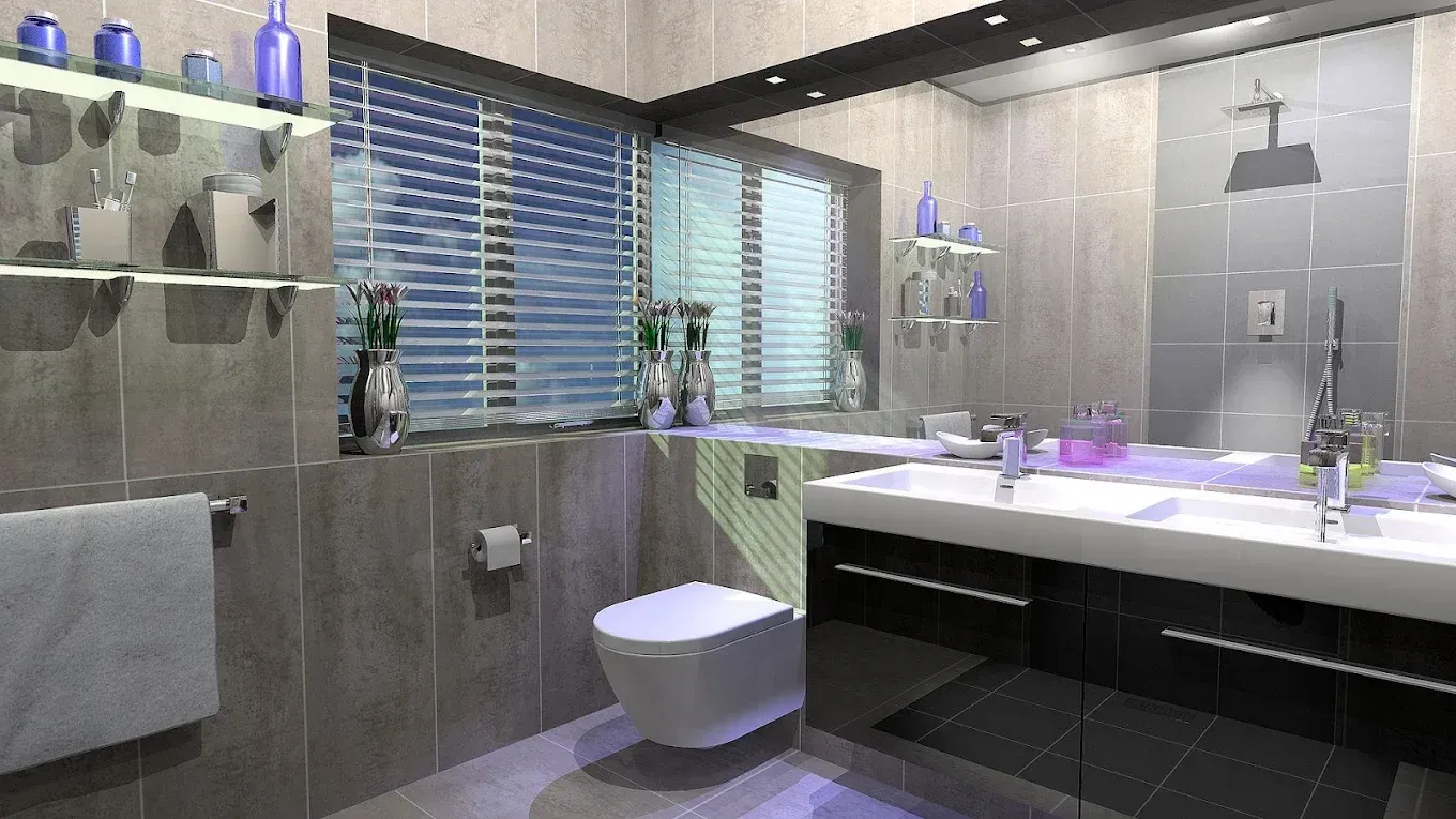 Modern bathroom with gray tile, toilet, sink, and window with blinds.