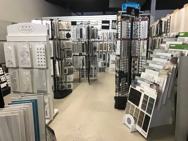 Inside a craft store, showcasing stamps and patterned paper on display racks, with a bright interior.