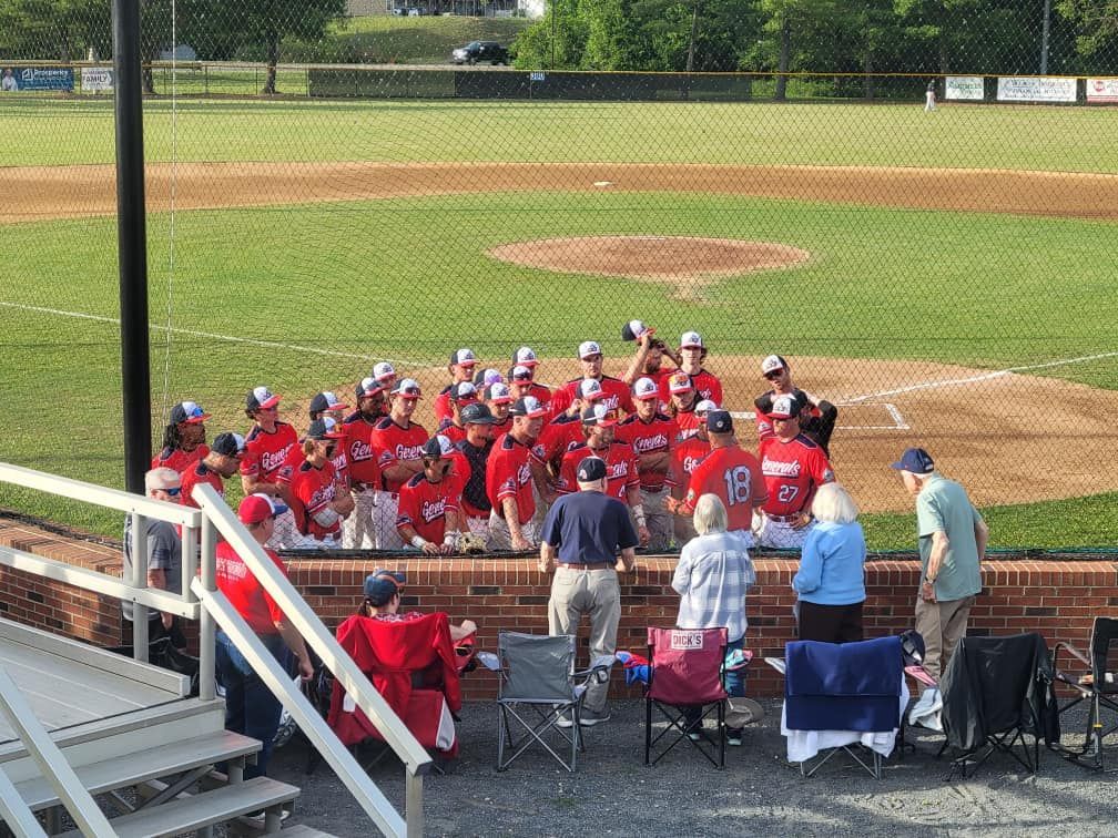 A group of people are watching a baseball game on a field.