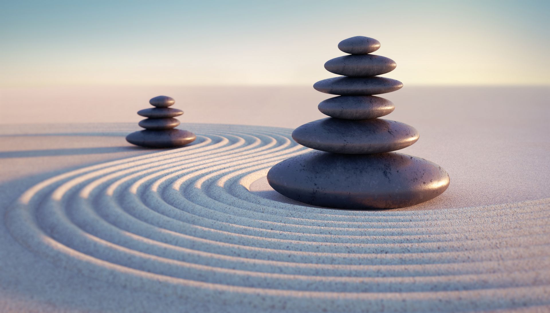 A couple of rocks stacked on top of each other in the sand.