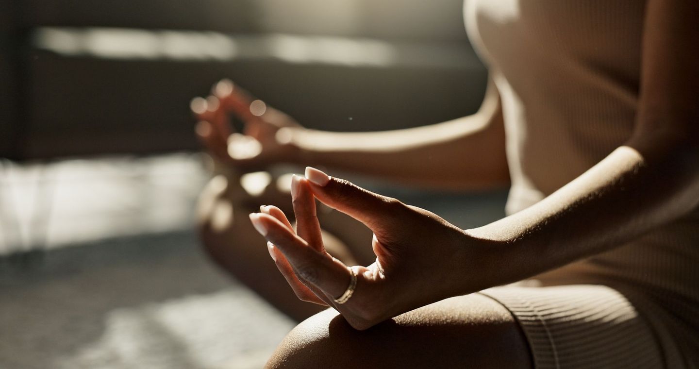 A woman is sitting in a lotus position with her legs crossed.
