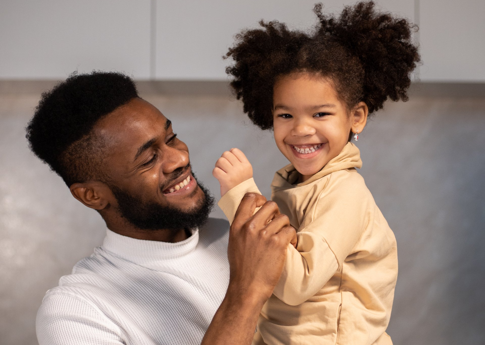 A dad is holding a his child in his arms.