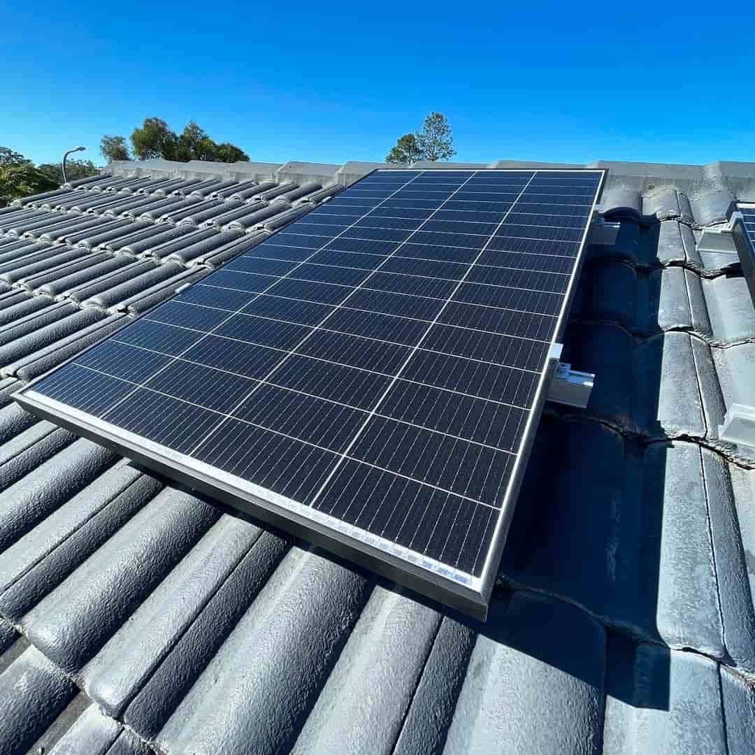 A Solar Panel Is Sitting On Top Of A Tiled Roof — KARM Electrical Services In Salamander Bay, NSW