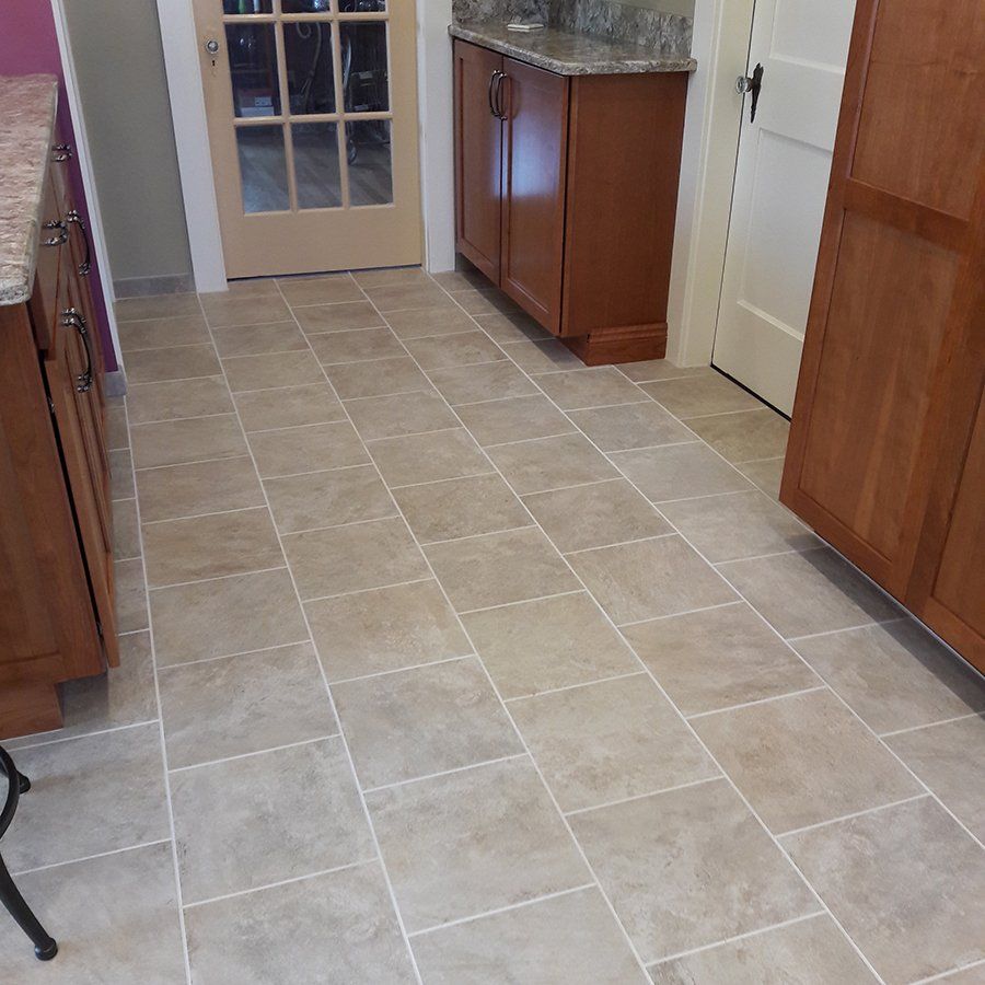A kitchen with tile floors and wooden cabinets