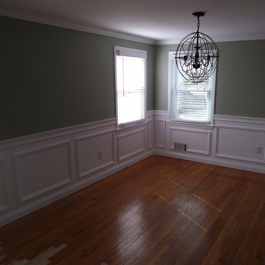 An empty room with a chandelier hanging from the ceiling