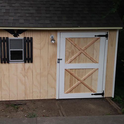 A wooden shed with a white door and a window