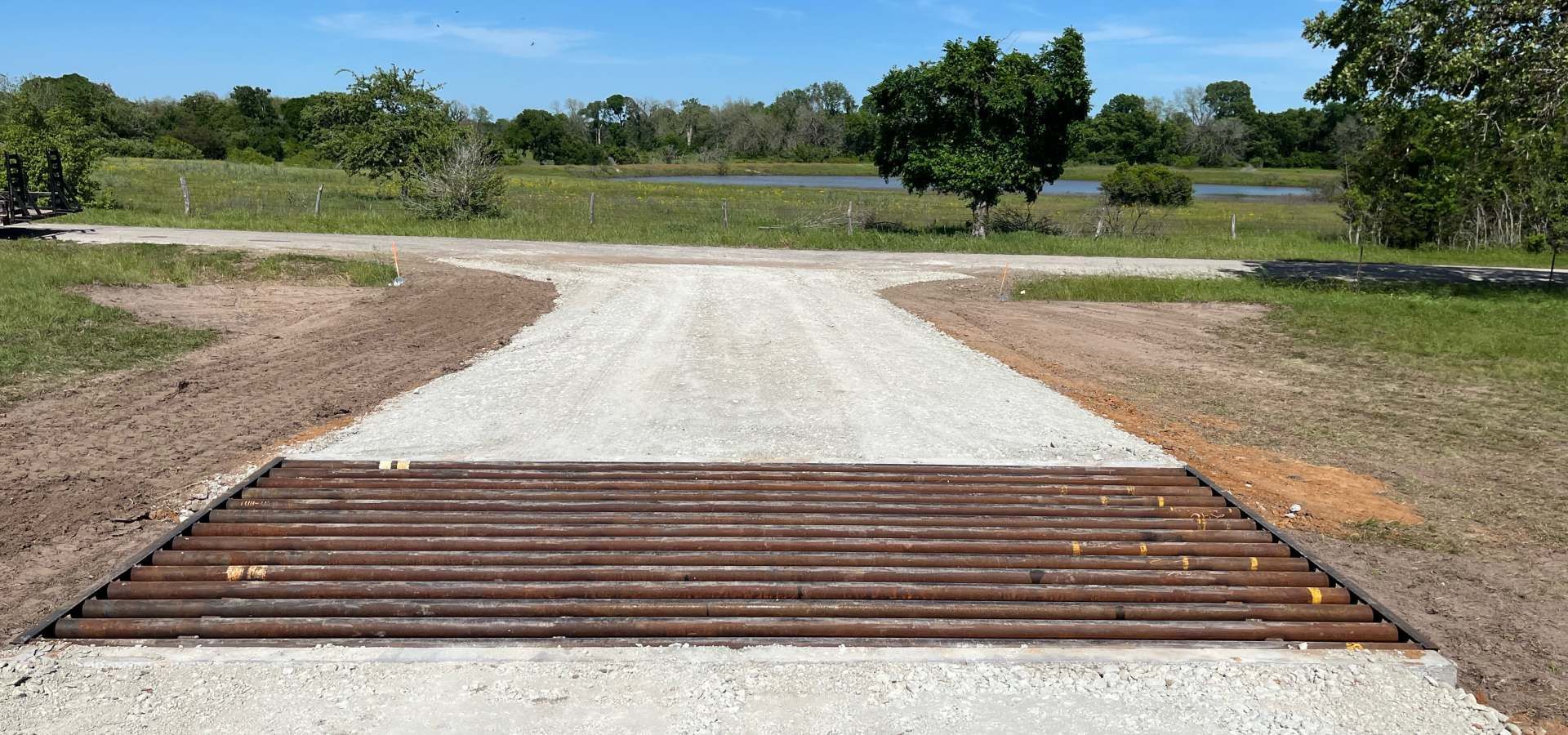A gravel road with a metal barrier on the side of it.