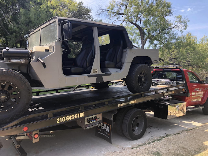 A jeep is sitting on top of a tow truck.