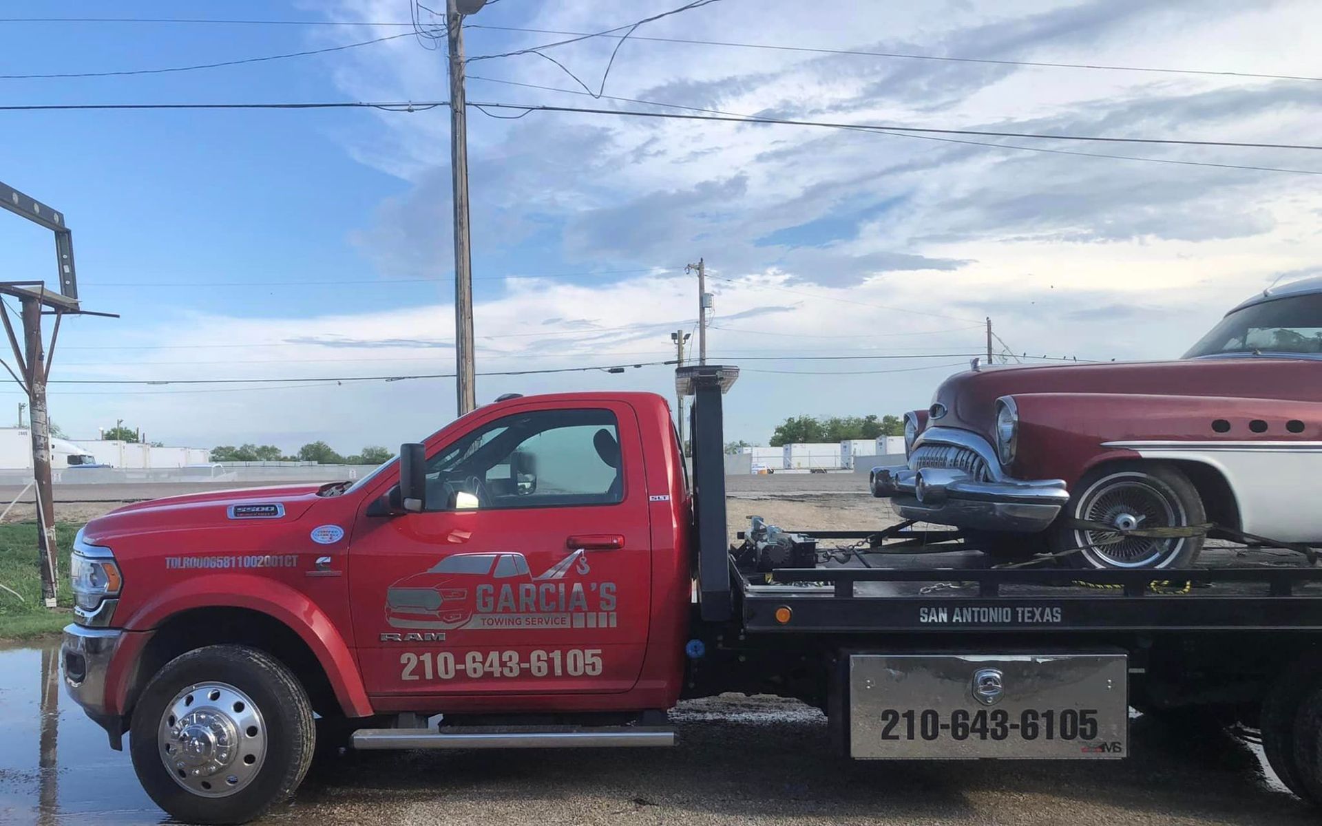 A red tow truck is carrying a red car on the back.