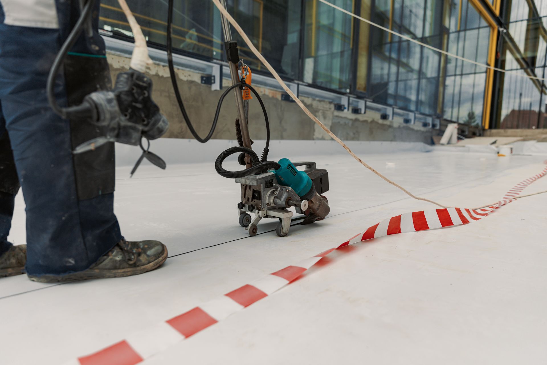 A man is working on a roof with a machine.