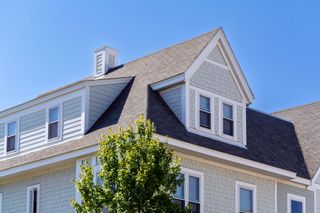 A house with a chimney on the roof and a tree in front of it