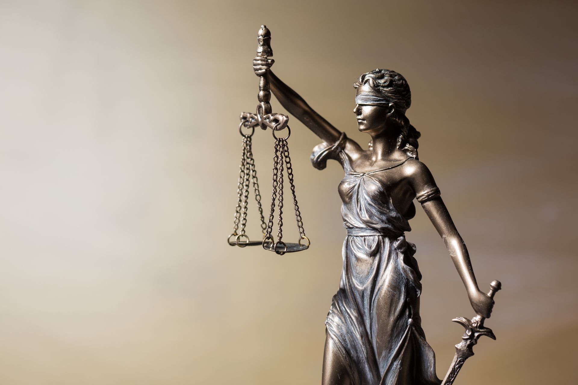 Statue of Lady Justice holding scales and sword, blindfolded, bronze