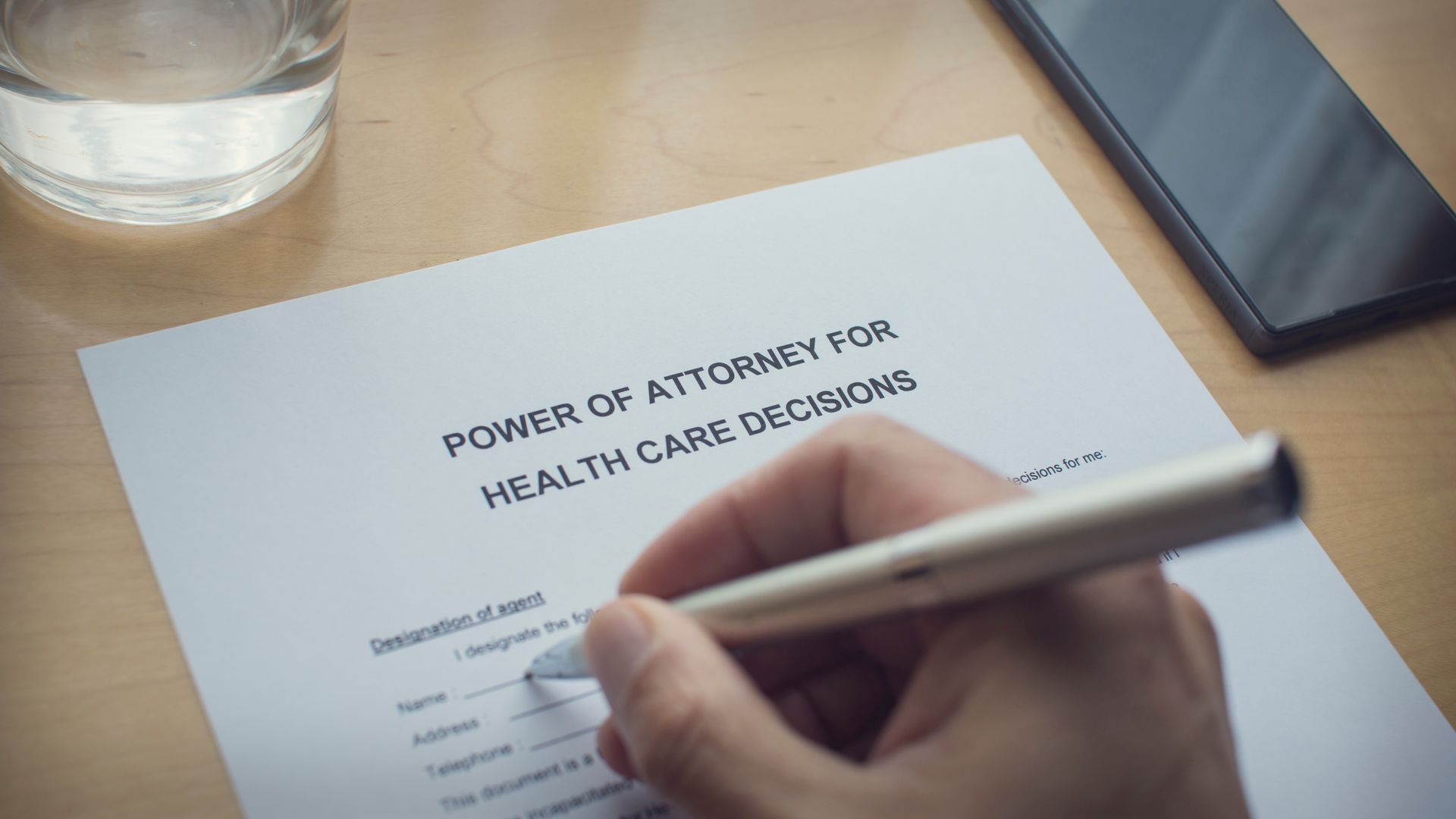 A person signing a Power of Attorney for Health Care Decisions document A person signing a Power of Attorney for Health Care Decisions document