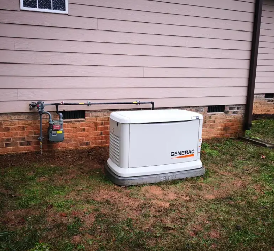 A Generac generator next to a house with a gas meter on brick foundation.