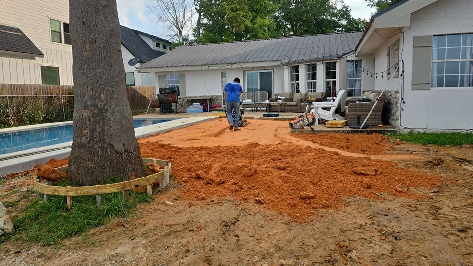 A man is standing in the dirt in front of a house.