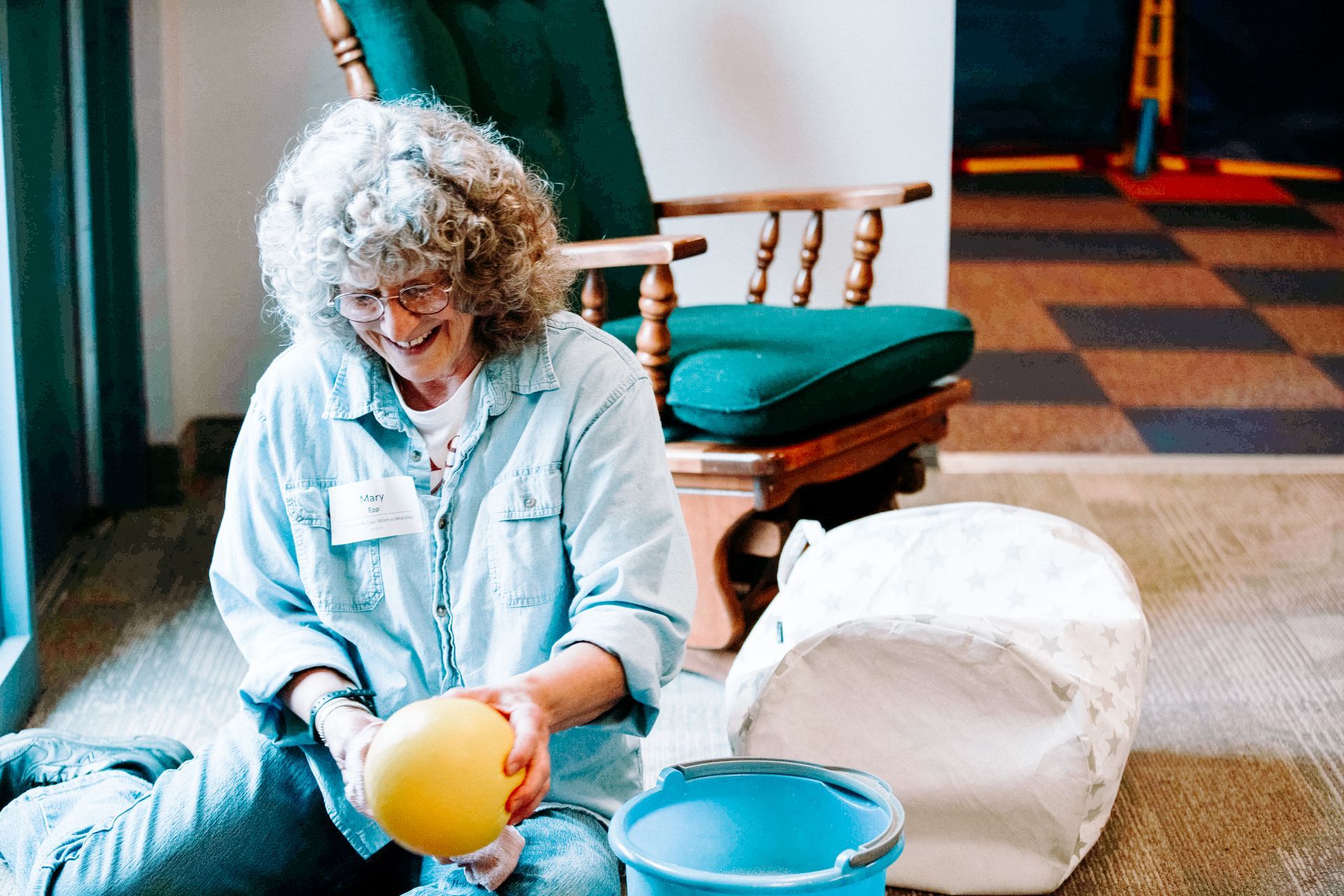 A woman and a teen are standing in front of a window to clean it. 