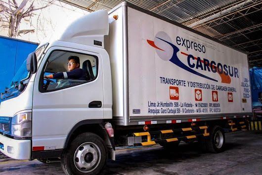 Un hombre conduce un camión blanco de carga exprés.