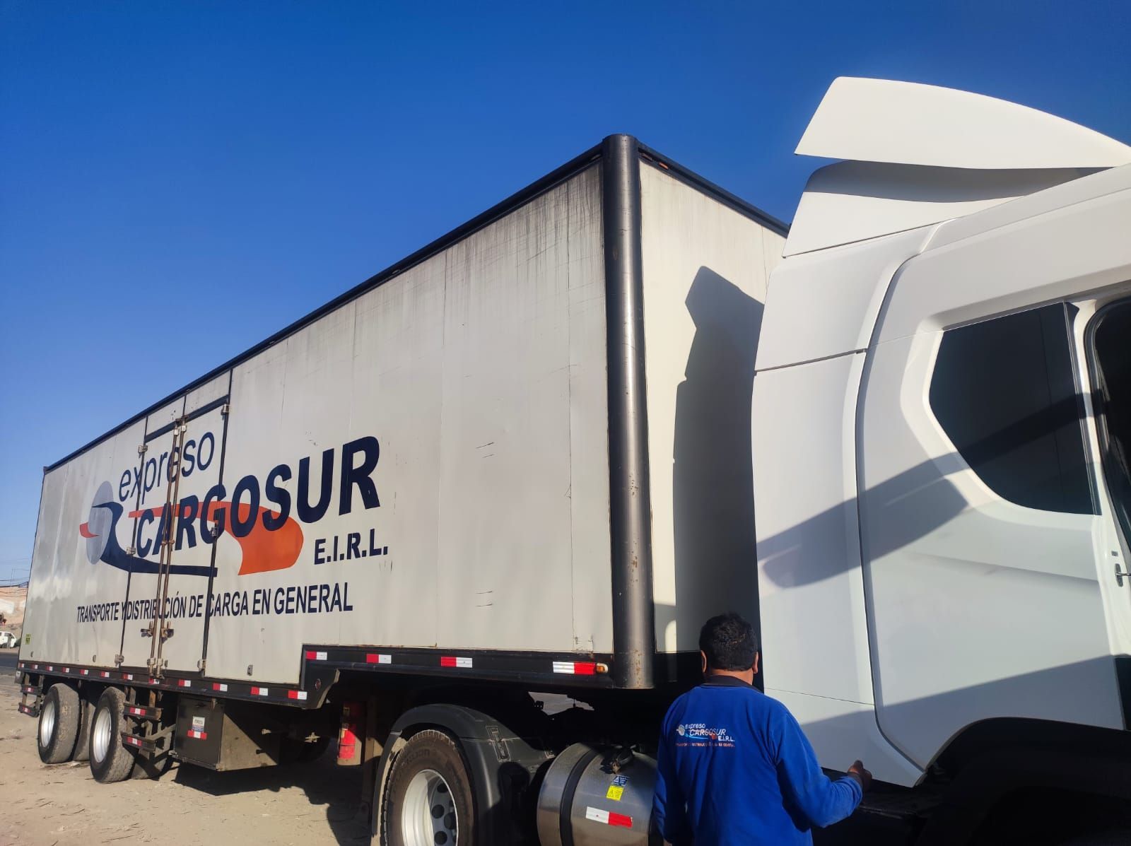 Un hombre está trabajando en un camión de carga.