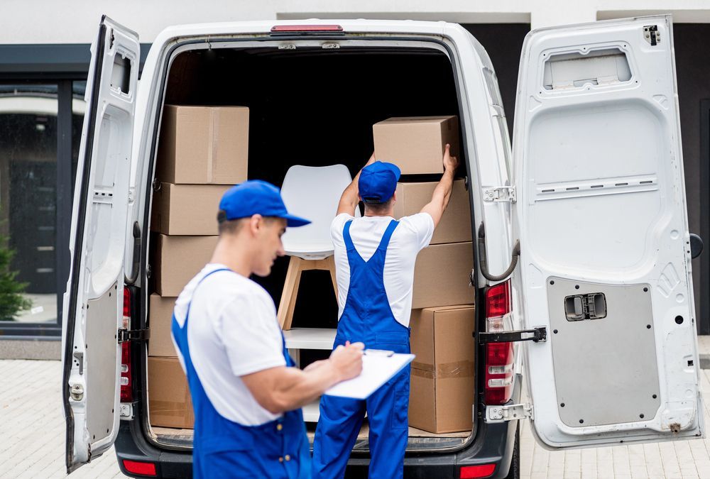 Dos hombres están cargando cajas en una camioneta.