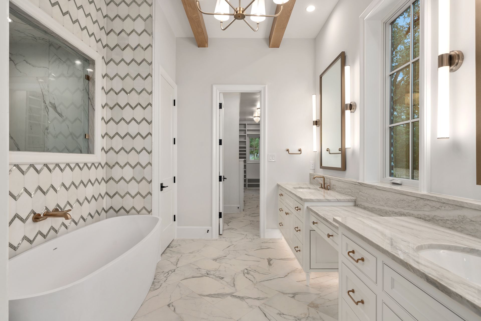 Modern kitchen with white cabinets, gray island, stainless steel appliances, and granite countertops.
