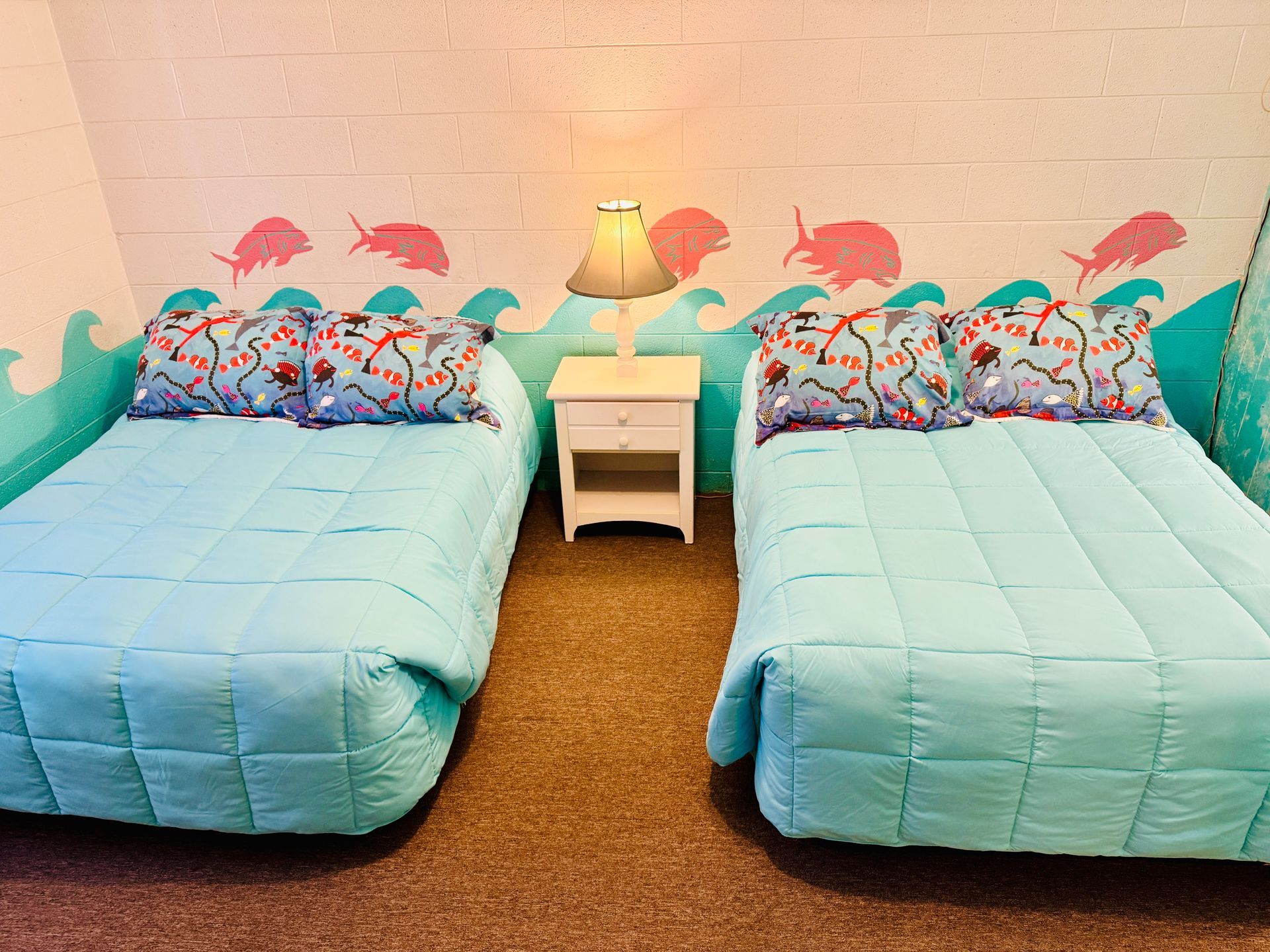 A hotel room with two beds and a pink table