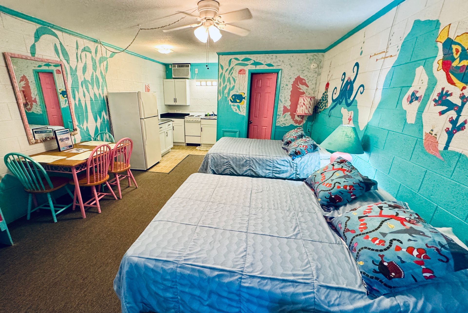 A bedroom with two beds , a futon , and a ceiling fan