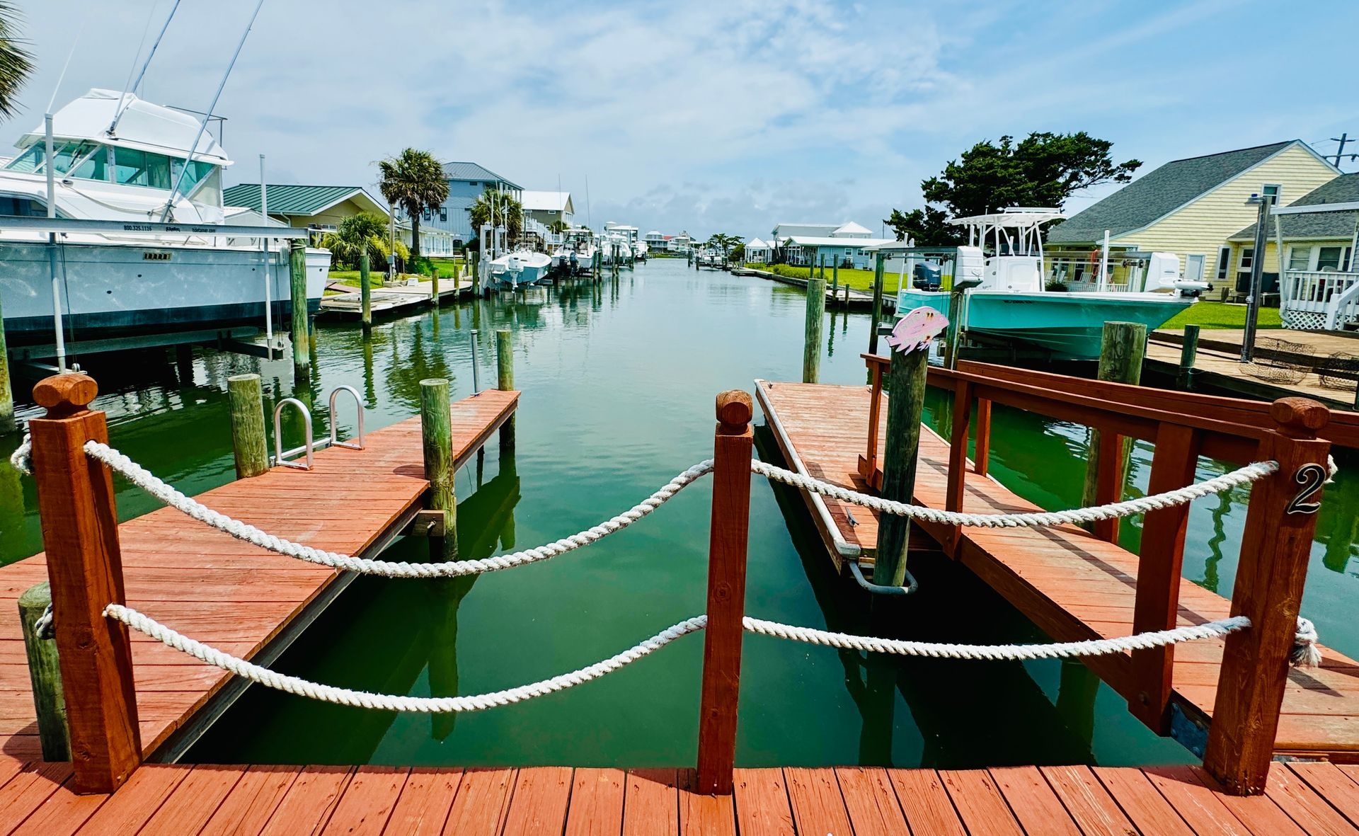 A wooden dock with ropes leading to a body of water.