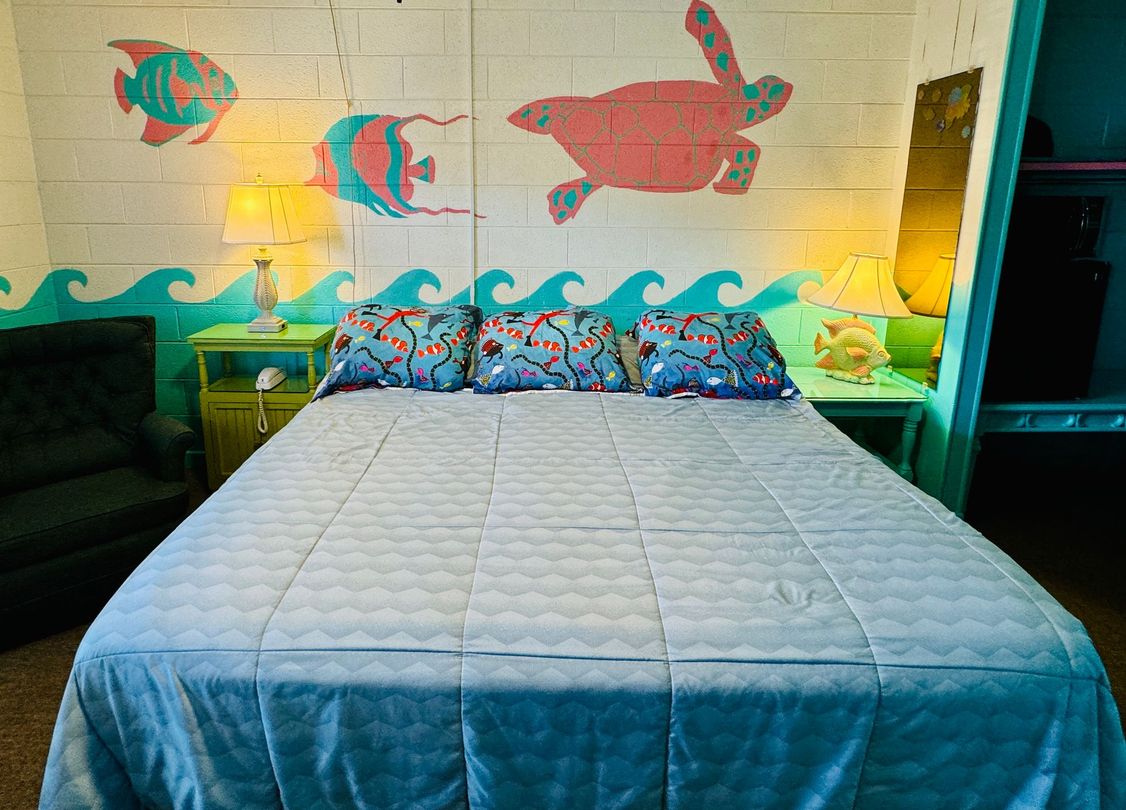 A bedroom with a bed and a turtle painted on the wall