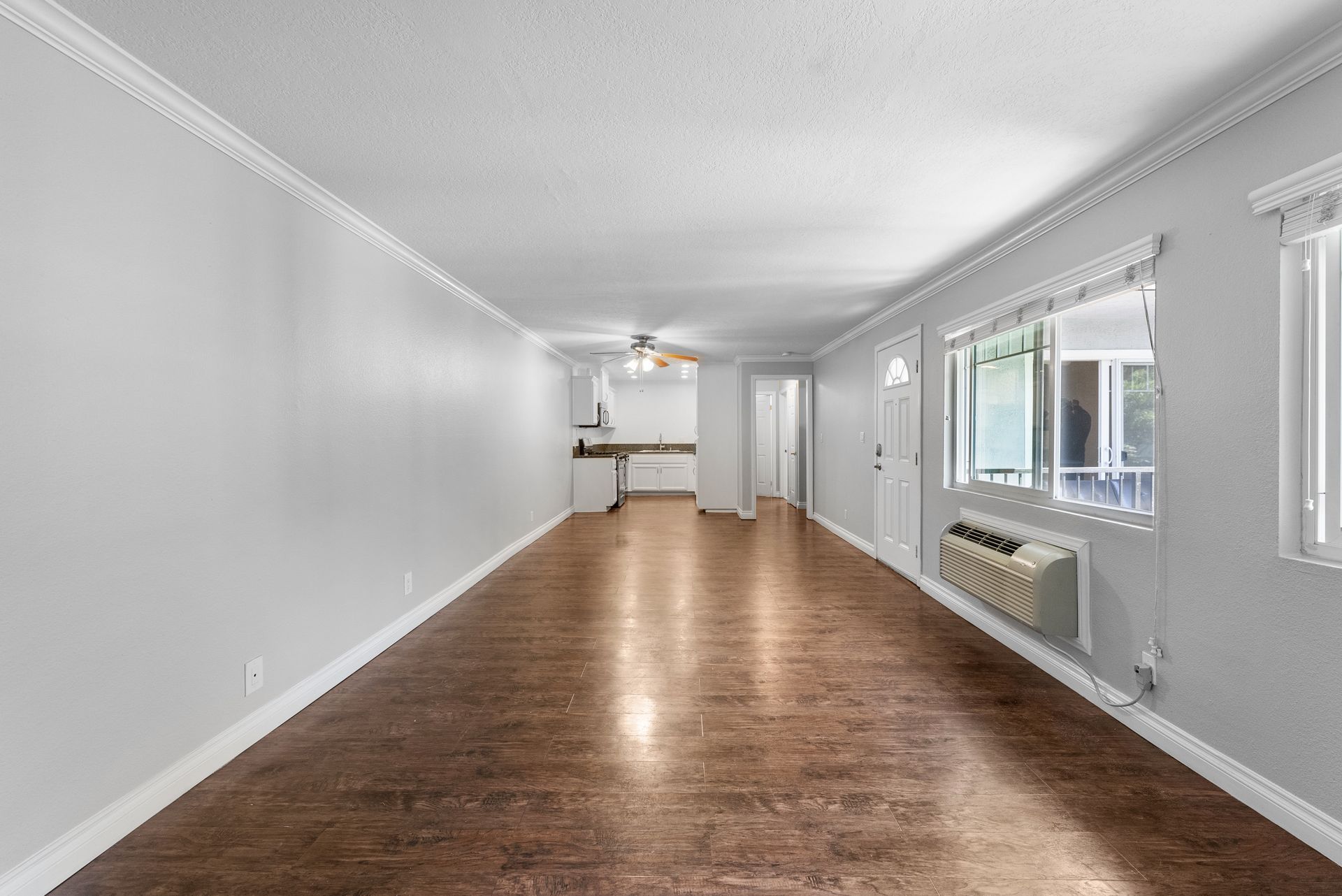 Wood floored living room with air conditioning unit