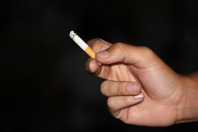hand holding a burning cigarette