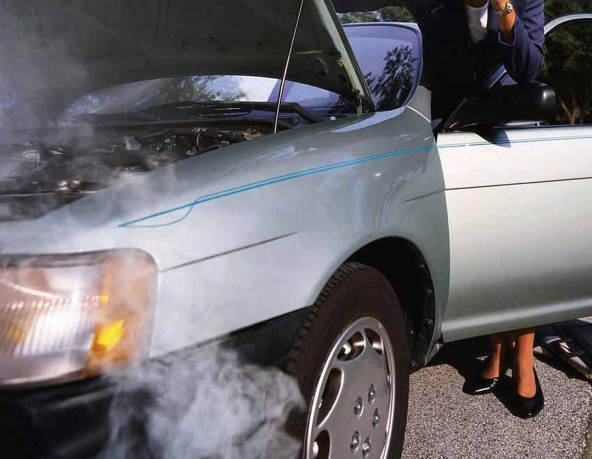 Smoke is coming out of the hood of a car