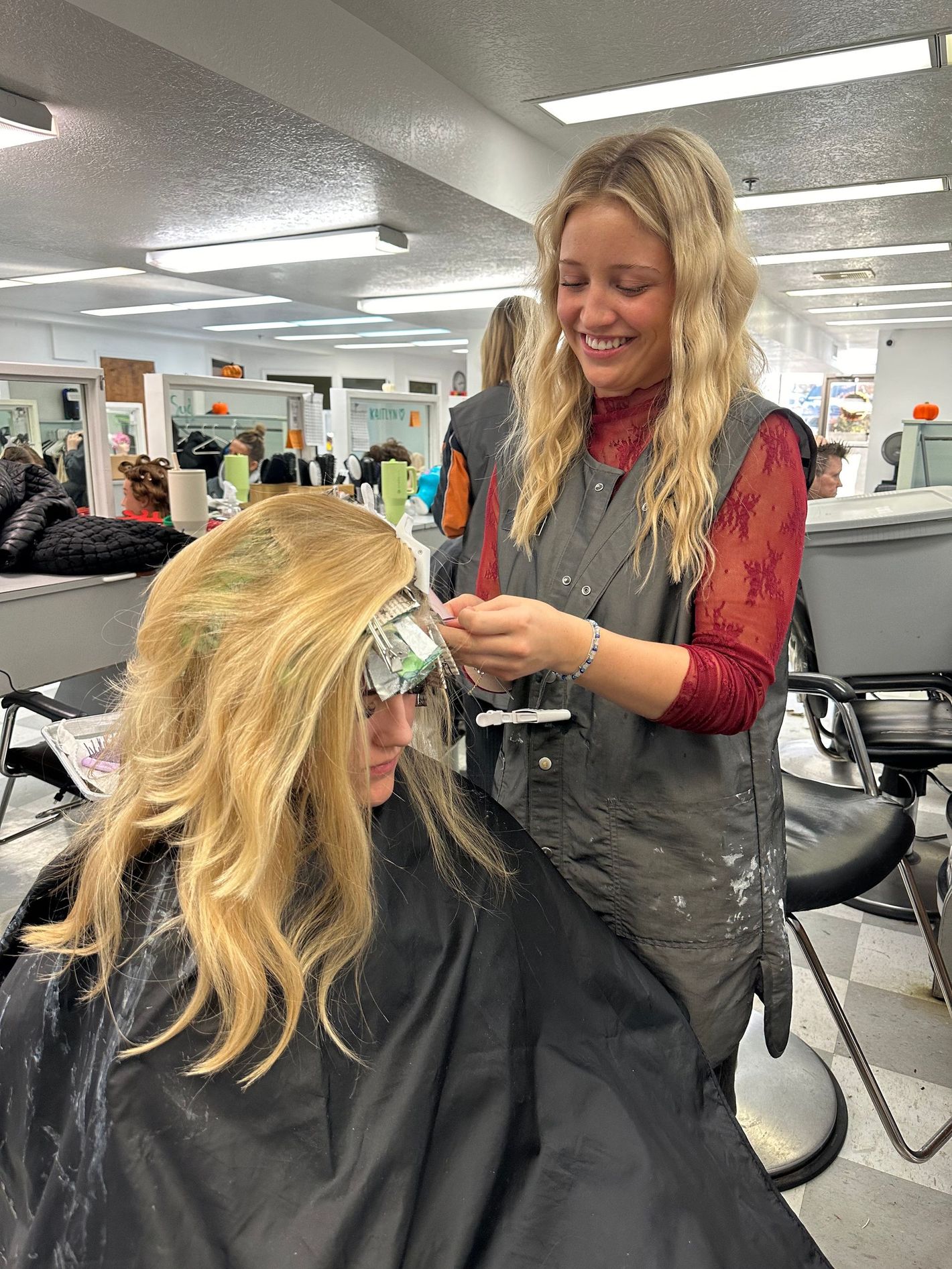 A woman is getting her hair dyed in a salon.