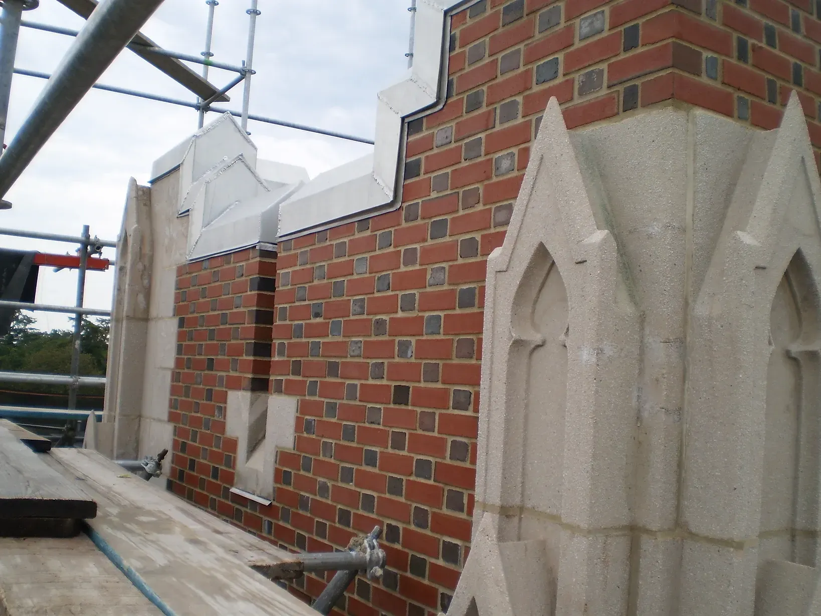 A brick building is being built with scaffolding around it