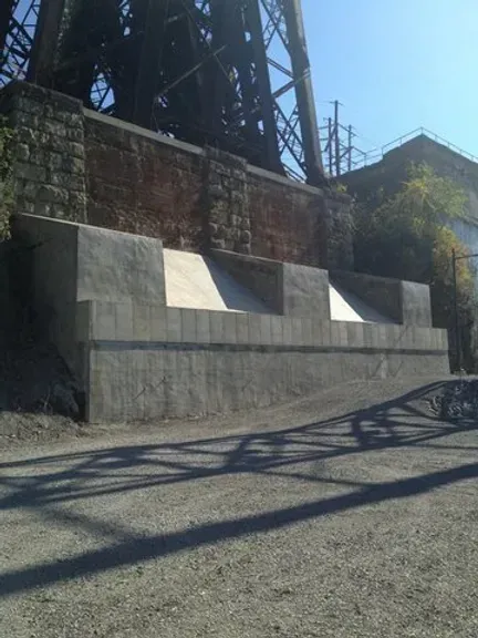 A concrete structure with a bridge in the background