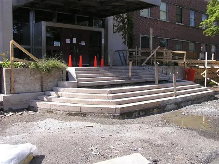 A building with stairs and orange cones in front of it