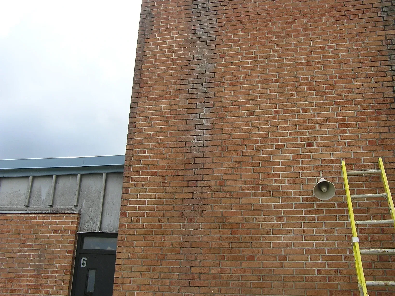 A brick building with a yellow ladder on the side