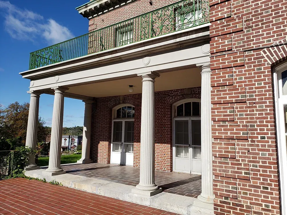 A large brick building with a balcony and columns