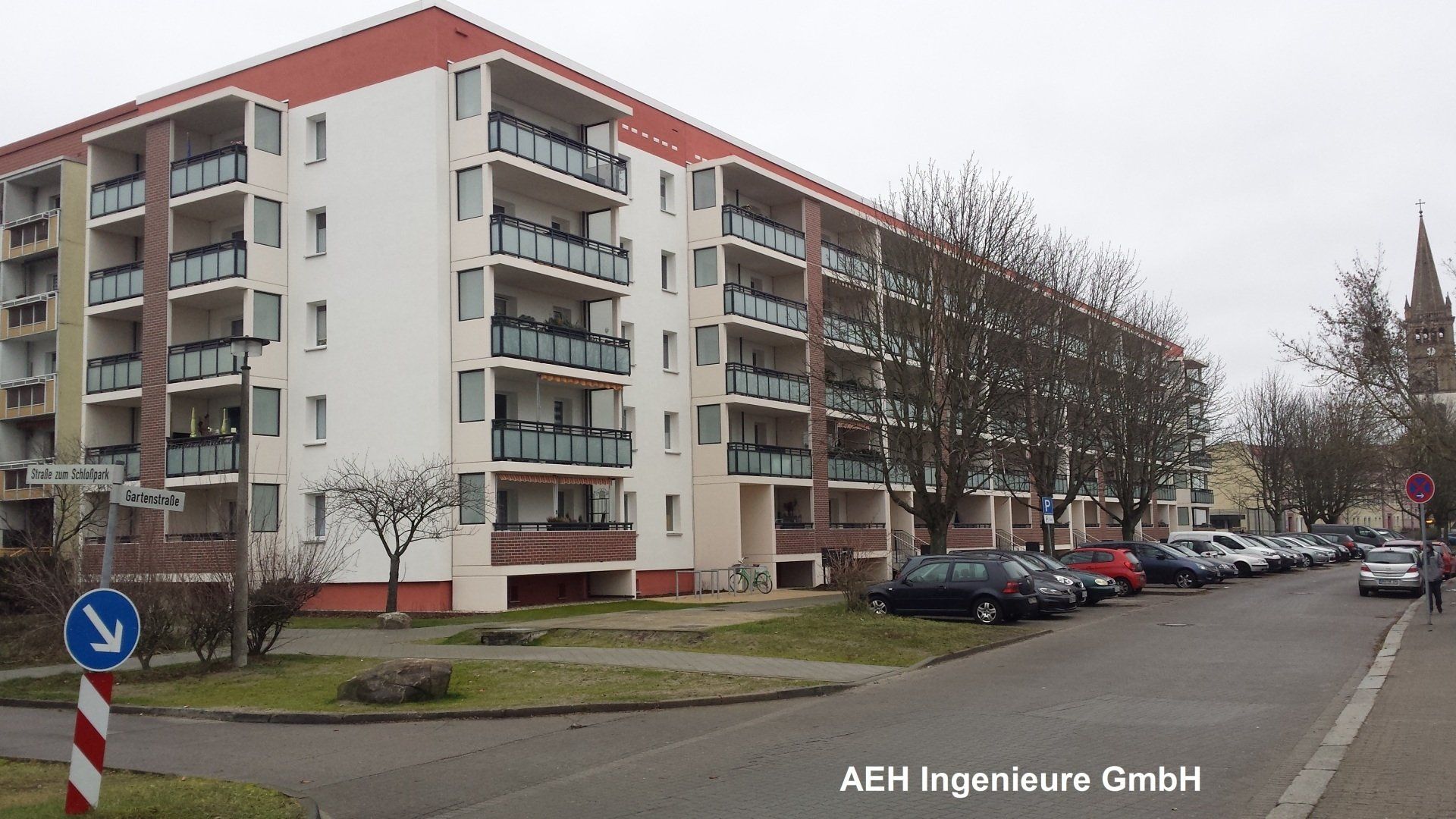 Ein großes Wohnhaus mit davor geparkten Autos