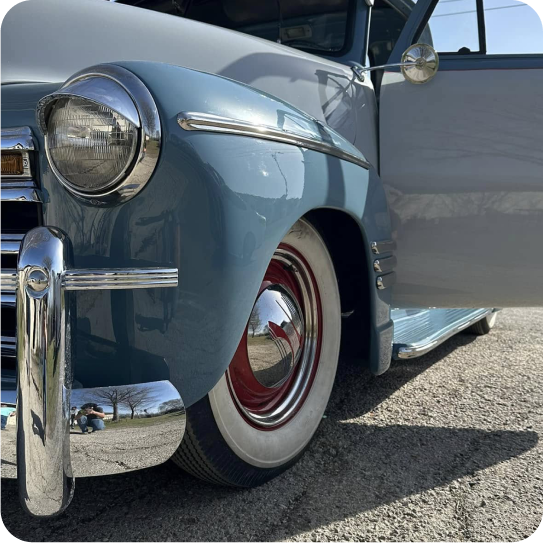 Blue classic car with chrome accents and whitewall tires; door open. | Alex's Paint Body