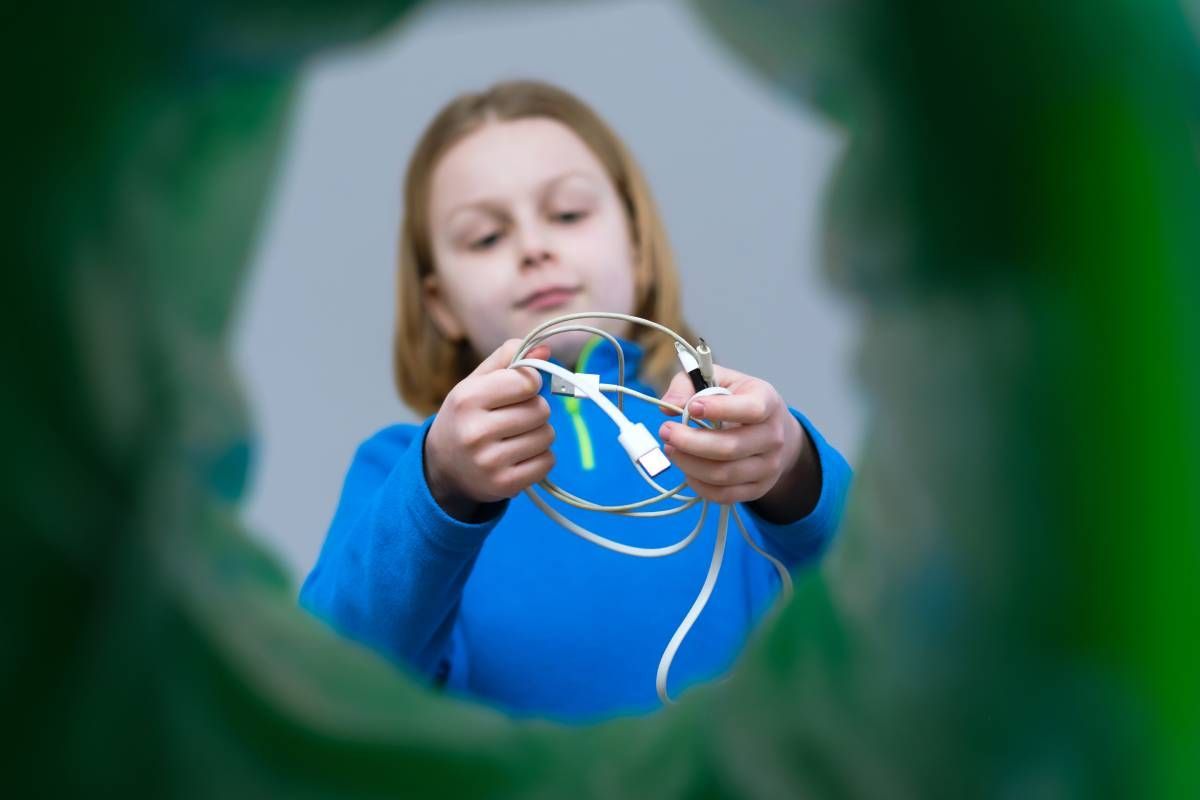 A girl disposing of unwanted cords at an electronic recycling center near Lexington, Kentucky (KY)