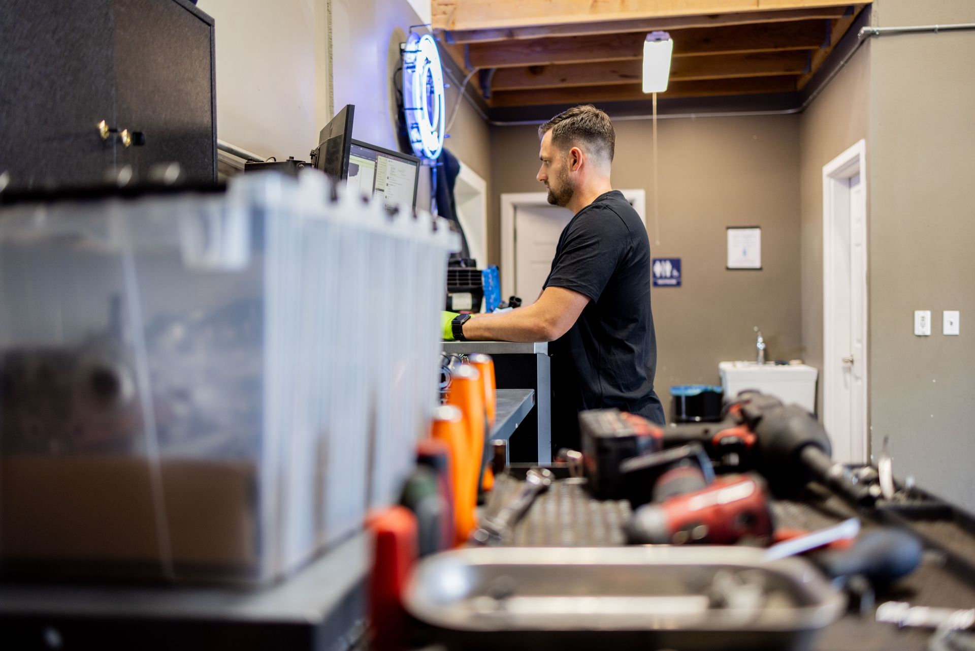 Mechanic working at a workbench in a garage. Tools and equipment are visible. | Peak Euro