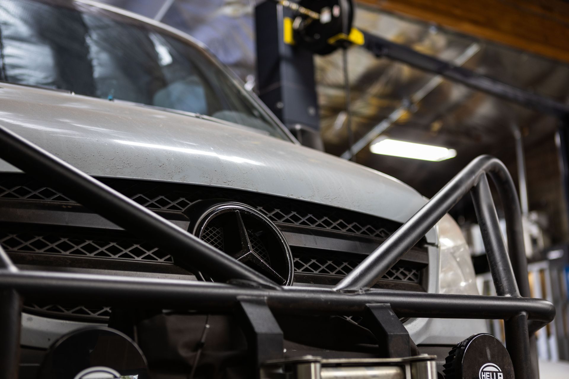 Grey Mercedes-Benz van with a black brush guard in a workshop setting.| Peak Euro