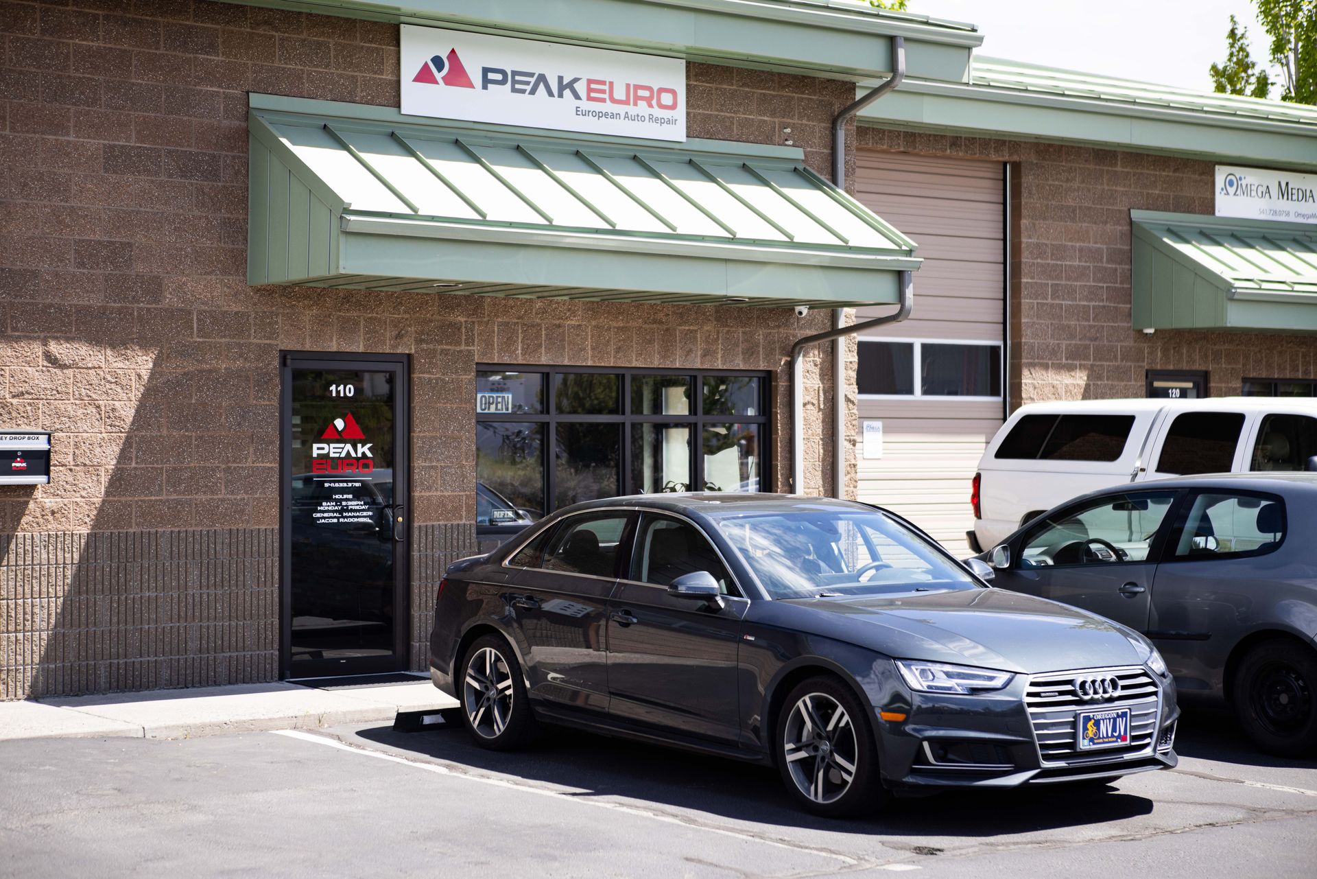 A gray Audi sedan parked outside Peak Euro auto repair shop. | Peak Euro