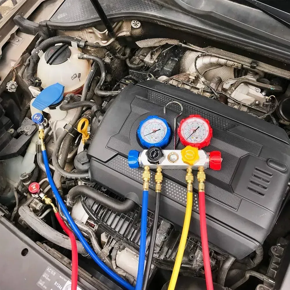 Car engine being serviced with gauges and hoses connected.